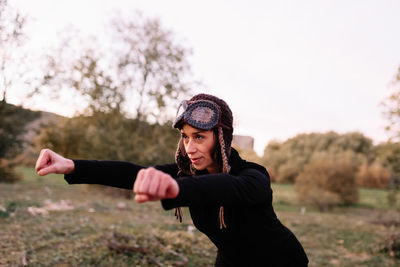 Smiling woman wearing knit hat exercising at park