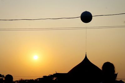 Silhouette of power lines against sky during sunset