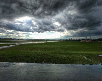 Scenic view of field against cloudy sky