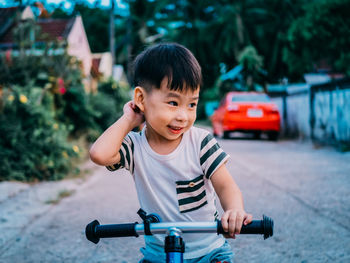 Cute boy riding push scooter outdoors