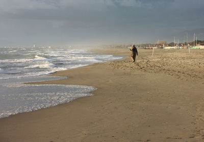 Woman on beach against sky