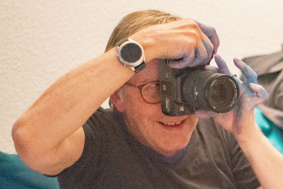 Close-up portrait of smiling man holding camera