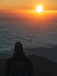 Rear view of silhouette man looking at sunset