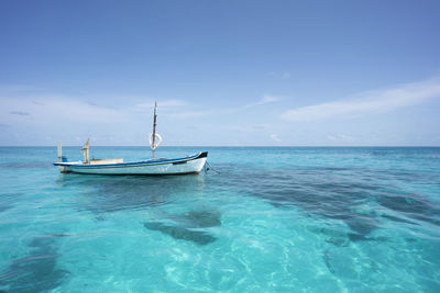 Sailboats in sea against blue sky