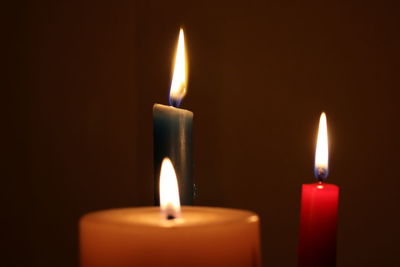 Close-up of lit candles against brown background