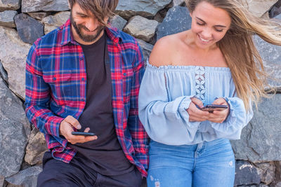 Full length of young man using smart phone outdoors