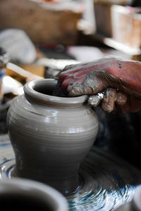 Midsection of man working on pottery wheel