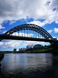 View of bridge over river against cloudy sky