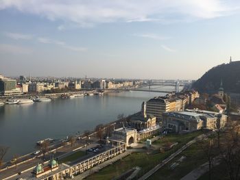 High angle view of buildings by river against sky