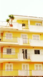 Low angle view of yellow building against sky