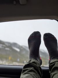 Low section of teenage boy wearing socks in car