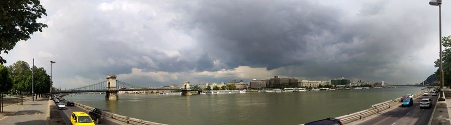 Bridge over river against cloudy sky