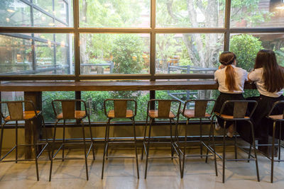 Rear view of women sitting on table in cafe