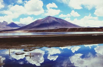 Scenic view of lake and mountains against cloudy sky