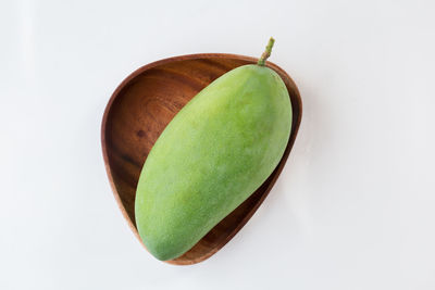 High angle view of green fruit against white background