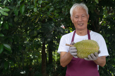 Portrait of smiling man holding plant