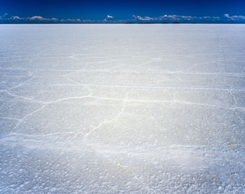 Surface level of snow covered landscape against blue sky