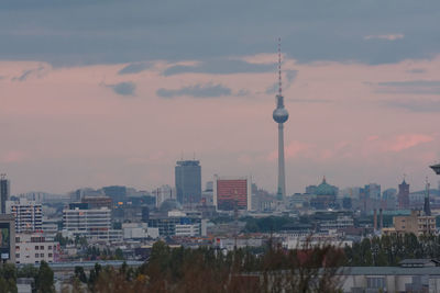 Buildings in city against cloudy sky