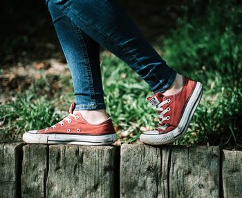 Low section of woman standing on wood