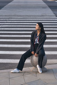 Full length of young woman sitting on steps