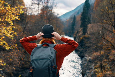 Rear view of man standing by tree during autumn