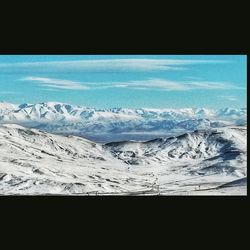 Scenic view of snow covered mountains against blue sky