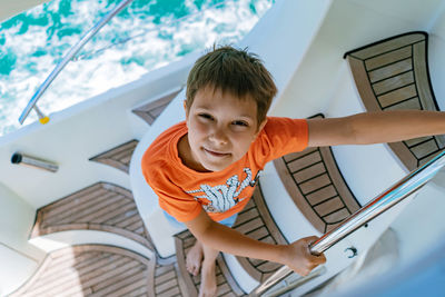 Boy sailing on yacht going down the stairs from deck