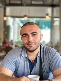 Portrait of young man sitting at cafe