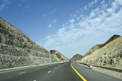 Road leading towards mountain against sky