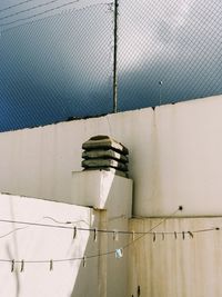 Close-up of metallic wall against fence