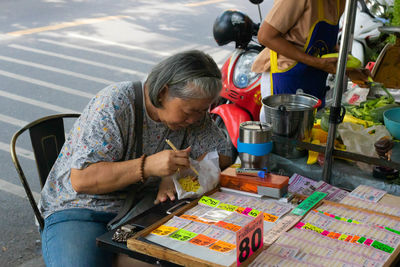 Rear view of man working on table