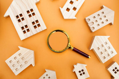 Magnifying glass and wooden houses. house searching concept. home appraisal. 