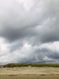 Scenic view of field against cloudy sky