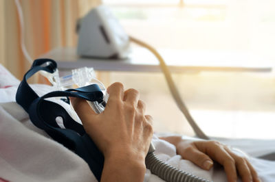 Midsection of woman lying down on bed