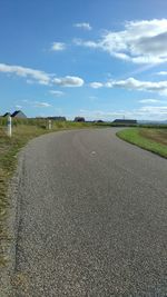 Curved empty road against cloudy sky