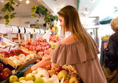 Side view of woman buying fruits at market