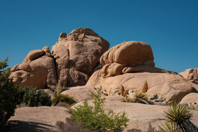 Low angle view of rocks against blue sky