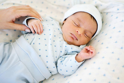 Mixed race infant boy sleeping in the baby cot