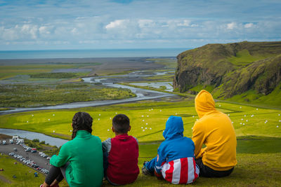 Rear view of people looking at sea against sky