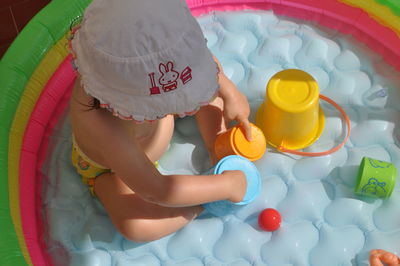 High angle view of girl playing in wading pool