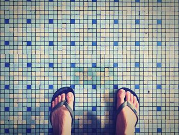 Low section of woman standing on tiled floor