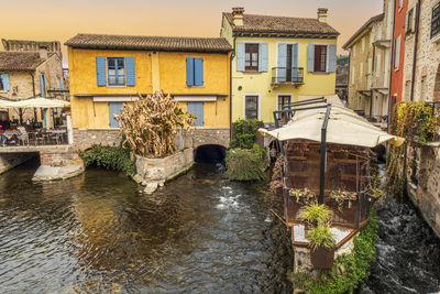 The beautiful colored houses of the hamlet of borghetto sul mincio reflecting on the water at sunset