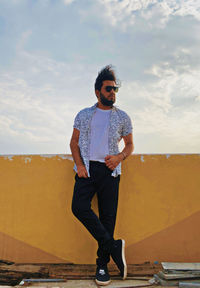 Portrait of young man standing against sky