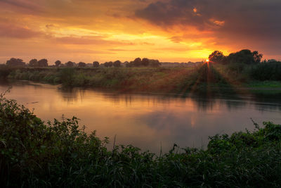 Scenic view of calm lake against dramatic sky