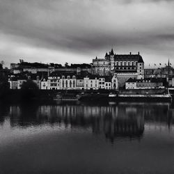 River in city against cloudy sky