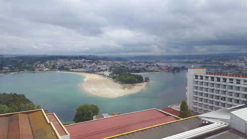 High angle view of cityscape by river against sky