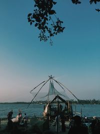 People on sea against clear sky