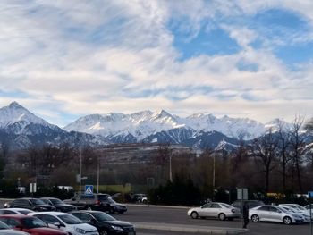 Cars on snow covered mountain against sky