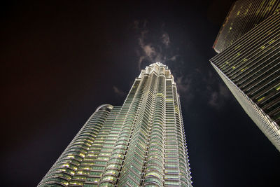 Low angle view of illuminated buildings against sky at night