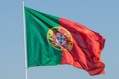 Low angle view of flag against blue sky